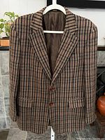 Full front view of brown herringbone DAKS blazer on hanger