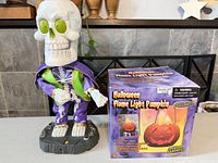 Skeleton figure with boxed pumpkin front view