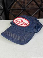 Front angled view showing denim bill, embroidered John Mayer patch