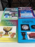 Four glass collecting reference books displayed cover up