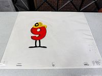Full cel with number 9 character wearing firefighter hat on paper backing
