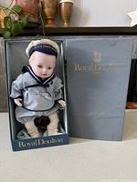 Doll in original Royal Doulton box with lid beside it