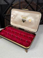 Open view of Stacy ring box showing red velvet slots and lid graphics