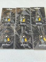 Front view of six sealed enamel pins on display cards