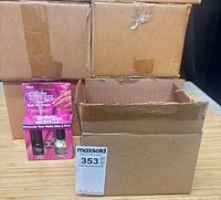 Four sealed brown cartons and one open carton displaying interior; single retail kit placed in front; MaxSold sticker visible
