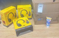 Three yellow RoadKing headset boxes, open carton with multiple sanitizer tubes, one tube displayed upright