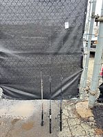 Full view of three fishing rods standing upright