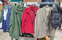 five jackets/vests hanging on rack
