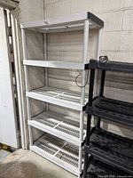 Full view of five-tier plastic shelving unit against wall
