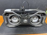 Front view of speaker with cord showing dual drivers and controls