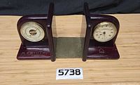 Full view of both wooden bookends showing barometer and clock dials and logos