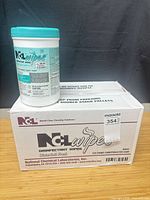 Canister of NCL Disinfectant Wipes atop sealed case, front labels visible