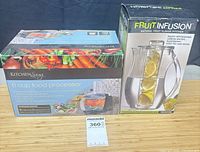 Front view of both boxed items: food processor and pitcher