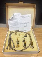 Boxed Harrington Victorian faucet set showing faucet bodies, side spray, hose and paperwork in foam insert