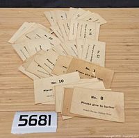 Pile of vintage Hotel Owosso Barber Shop numbered service cards spread on tabletop