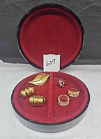 Open round lacquer jewelry box displaying all jewelry pieces