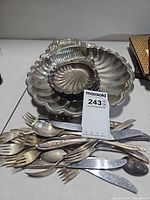 Large shell bowl with stacked small shell bowls and mixed flatware