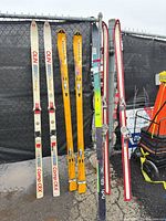 All four pairs of skis standing upright showing graphics and bindings