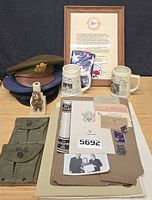 Overall lot showing caps, mugs, stein, figurine, framed certificate, pouch, binder and documents