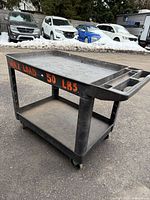 Three-quarter view showing overall cart, shelves, casters, side lettering