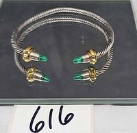 Full view of silvertone twisted cable cuff bracelet showing goldtone collars and green malachite tips