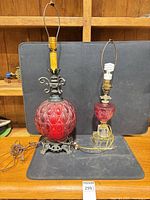 Both vintage red glass lamps side by side on surface