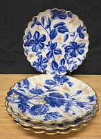 Five flow blue chrysanthemum plates showing pattern, scalloped and gilt edged