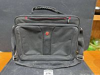 Front view of Wenger laptop briefcase showing logo, handle, front pocket and shoulder strap