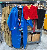 Overview of garments on rack: tan coat, blue embroidered robe, red jacket, black pants, striped garment