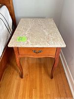 Overall view of end table showing marble top, wood body, cabriole legs, single drawer