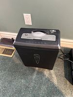 Front view of black paper shredder showing control panel and viewing window