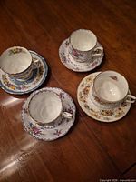 Four teacup and saucer sets arranged on table