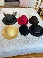 Overview of all six hats on bed