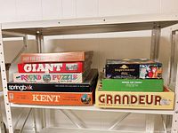 Full view of two stacks of boxed puzzles on shelf