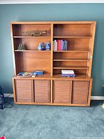 front view of entire bookcase showing open shelves and sliding-door cabinet