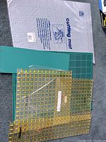 Overview of green cutting mats and yellow-grid acrylic rulers with packaged grey mat underneath