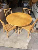 Round rattan dining table with four matching chairs