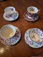 Four teacup and saucer sets displayed
