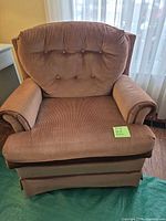 Front view of Sears corduroy club chair showing rolled arms, button-tufted back and skirted base
