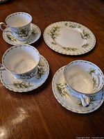 Full set showing three teacup-saucer pairs and dessert plate