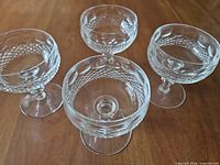 Top and side view showing four Waterford Colleen coupe glasses on wooden surface.