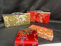 Group shot of four silk brocade coin purses showing colors and clasp style