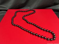 Necklace laid flat showing full strand of black beads