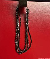 Full view of multi-strand hematite necklace hanging to show length and layers