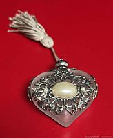 Full view showing heart shape, filigree, faux pearl, tassel