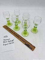 Six green stem cordial glasses beside 12-inch ruler