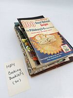 Stack of approximately 30 small recipe booklets showing top title '100 Prize Winning Grand National Recipes'