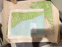 Stack of large folded maps with one displayed