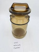 Front view of amber glass canister with lid on