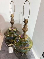 Both iridescent green glass lamps full view